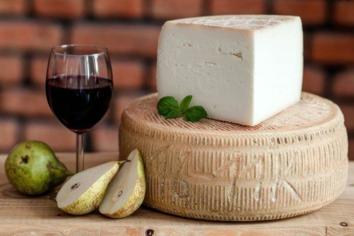 Kozi Grzbiet – twardy, dojrzewający ser kozi na desce serów z pieczywem i ziołami