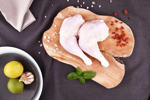 Udka z kurczaka EKO 600g na drewnianej desce z przyprawami