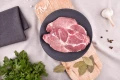Plastrer surowy karczek wieprzowy EKO 500g na drewnianej desce z przyprawami i ziołami