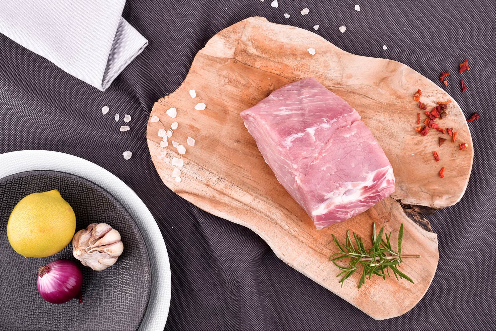 Surowy schab wieprzowy EKO bez kości 500g na drewnianej desce z przyprawami